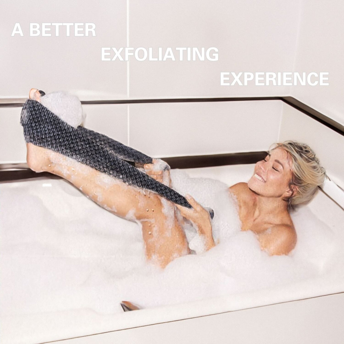 Woman enjoying Blissal exfoliating towel in a bubble bath for a relaxing self-care experience